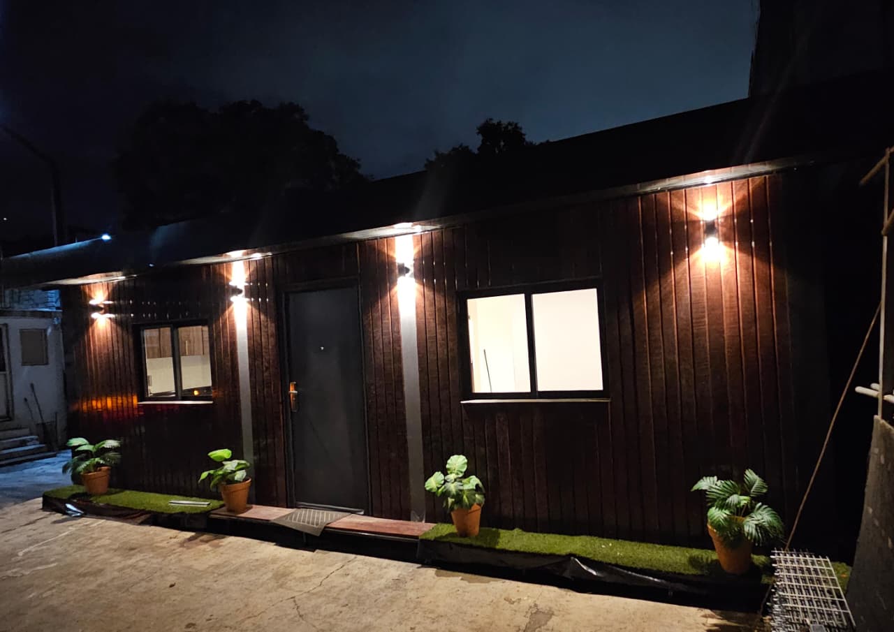 Fachada de la casa muestra Habitá+ iluminada de noche